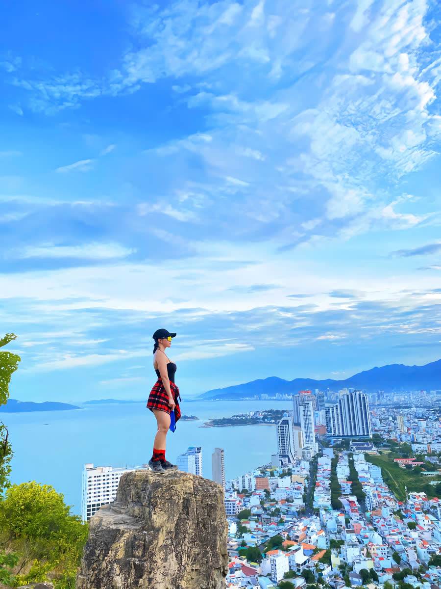 Người đứng trên mỏm đá Cô Tiên, phía dưới là thành phố Nha Trang và bờ biển